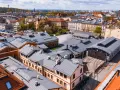 Widok z lotu ptaka na teren Muzeum Motoryzacji Kraków, z zabytkowymi budynkami i torami kolejowymi.