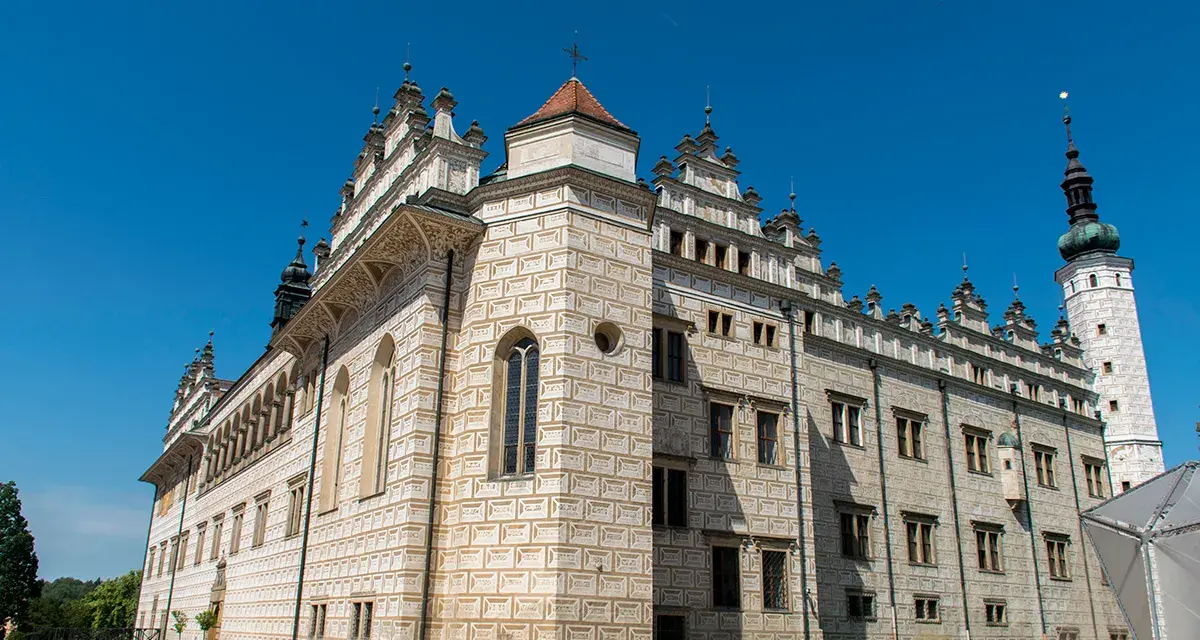 Zamek w Litomyślu, z jego unikalną sgraffitową fasadą, prezentuje się majestatycznie na tle błękitnego nieba.