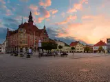 Rynek w Tarnowskich Górach o zachodzie słońca, z ratuszem i kolorowymi kamienicami.