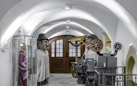 W muzeum Kargula i Pawlaka, wielkie kukły bohaterów filmu stoją obok starego projektora filmowego.