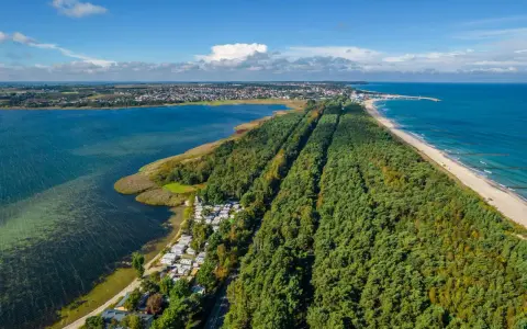 Półwysep Helski widziany z lotu ptaka: las sosnowy, plaża, morze i zatoka. Widać też miasteczko i kemping.