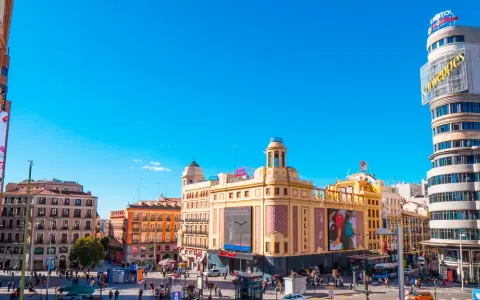 Tętniący życiem plac w Madrycie, idealny na jednodniową wycieczkę. Zobaczysz tu charakterystyczny budynek Capitol z neonem Schweppes i kino Callao.