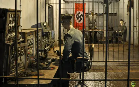 Wnętrze mamerki bunkrów z manekinami żołnierzy i niemiecką flagą. Na pierwszym planie manekin przy konsoli, w tle dwaj żołnierze.