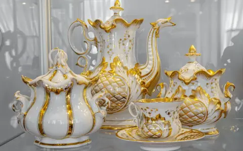Elegancka zastawa kawowa z Muzeum Porcelany Wałbrzych, zdobiona złotem i motywami roślinnymi, zachwyca kunsztem wykonania.