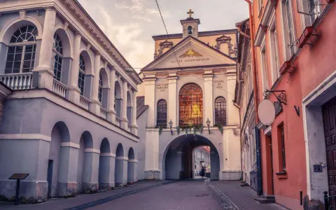 Brama w Ostrej Bramie, serce starego miasta Wilna, wita przechodniów łukiem i zabytkową architekturą.