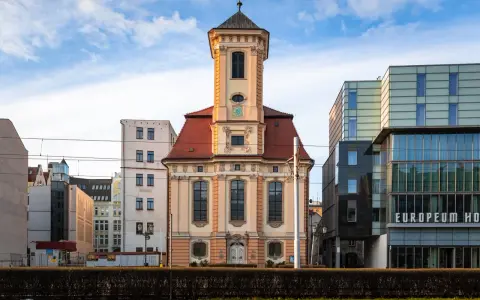 Wrocławski **dzielnica czterech świątyń** to kontrast historii i nowoczesności. Stara kamienica obok szklanego hotelu.