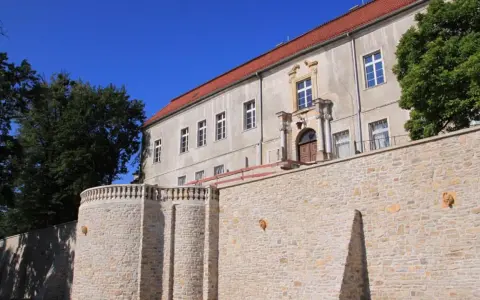 Krapkowice zamek zwiedzanie: kamienne mury i zabytkowy budynek zamku pod błękitnym niebem.