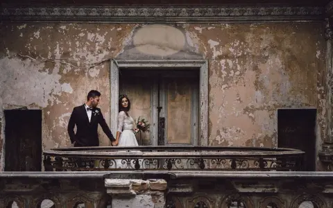 Para młoda trzyma się za ręce na balkonie zniszczonego pałacu. Zwiedzanie Krowiarki to niezwykłe doświadczenie.