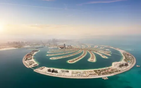 Palma Jumeirah, jedna z najbardziej spektakularnych dubajskich atrakcji, rozpościera się na tle błękitnego nieba i turkusowego morza.