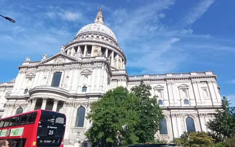 Majestatyczna katedra św. Pawła w Londynie, czerwony piętrowy autobus i błękitne niebo. Idealny widok na udany weekend w Londynie.