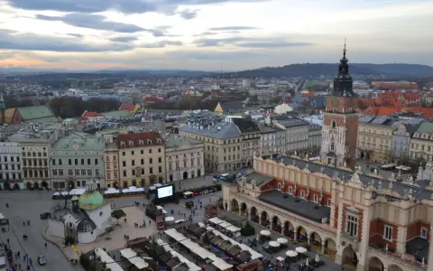 Widok na Rynek Główny w Krakowie z dominującą wieżą Mariacką. W dole kramy jarmarku, Sukiennice i kościółek.