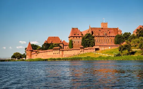 Potężny zamek w Malborku nad rzeką. Zwiedzanie zamku w Malborku to podróż w czasie.