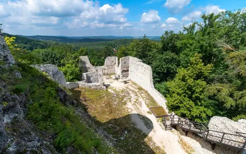 Ruiny zamku Pilcza w Smoleniu, otoczone bujną zielenią, z widokiem na malownicze wzgórza.