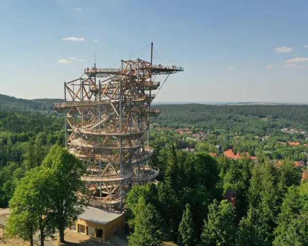 Drewniana wieża Sky Walk wznosi się ponad zielonym lasem, oferując zapierające dech w piersiach widoki na okolicę i miasteczko.