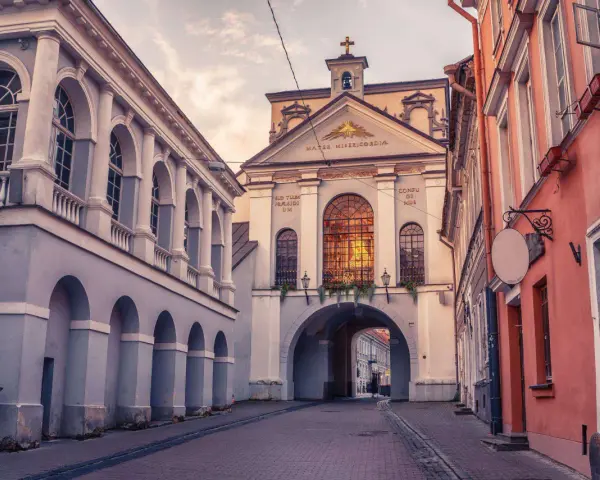 Brama w Ostrej Bramie, serce starego miasta Wilna, wita przechodniów łukiem i zabytkową architekturą.