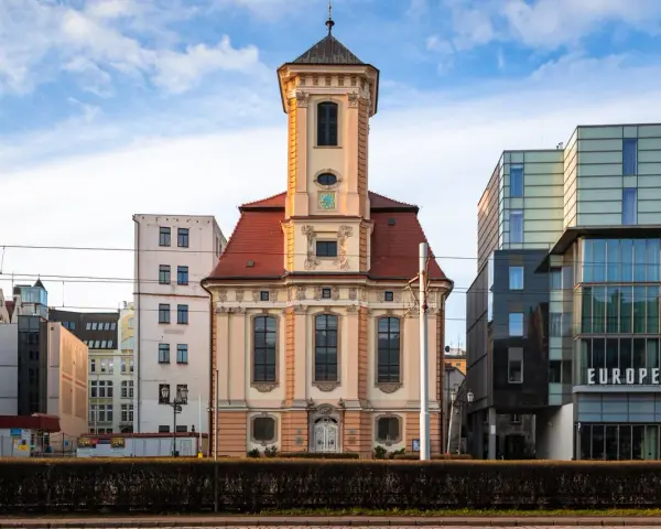 Wrocławski **dzielnica czterech świątyń** to kontrast historii i nowoczesności. Stara kamienica obok szklanego hotelu.