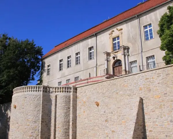 Krapkowice zamek zwiedzanie: kamienne mury i zabytkowy budynek zamku pod błękitnym niebem.