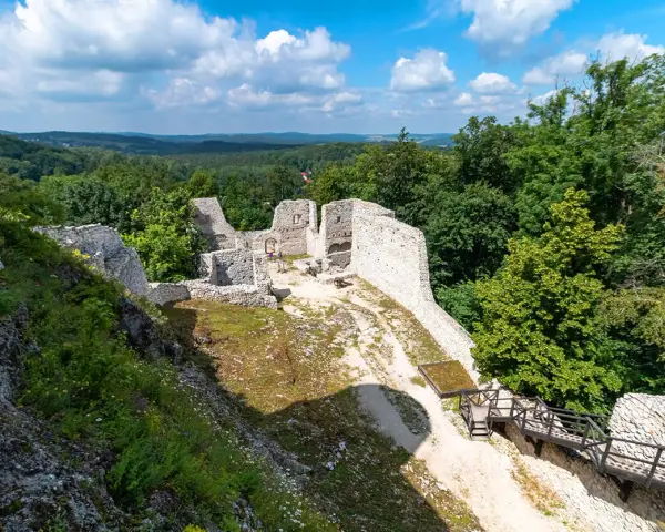 Ruiny zamku Pilcza w Smoleniu, otoczone bujną zielenią, z widokiem na malownicze wzgórza.