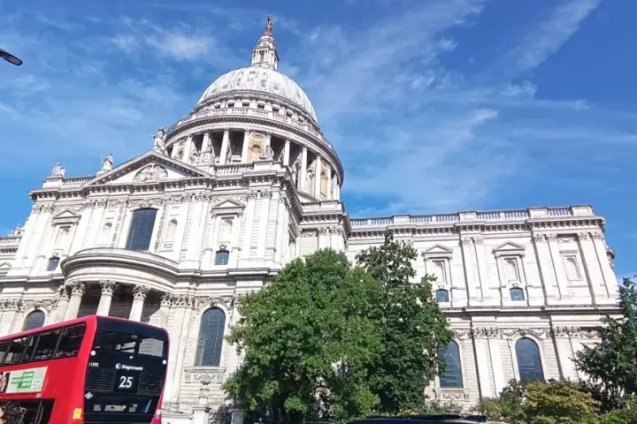 Majestatyczna katedra św. Pawła w Londynie, czerwony piętrowy autobus i błękitne niebo. Idealny widok na udany weekend w Londynie.