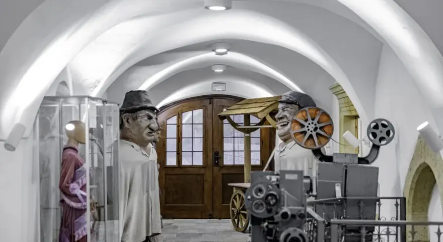 W muzeum Kargula i Pawlaka, wielkie kukły bohaterów filmu stoją obok starego projektora filmowego.