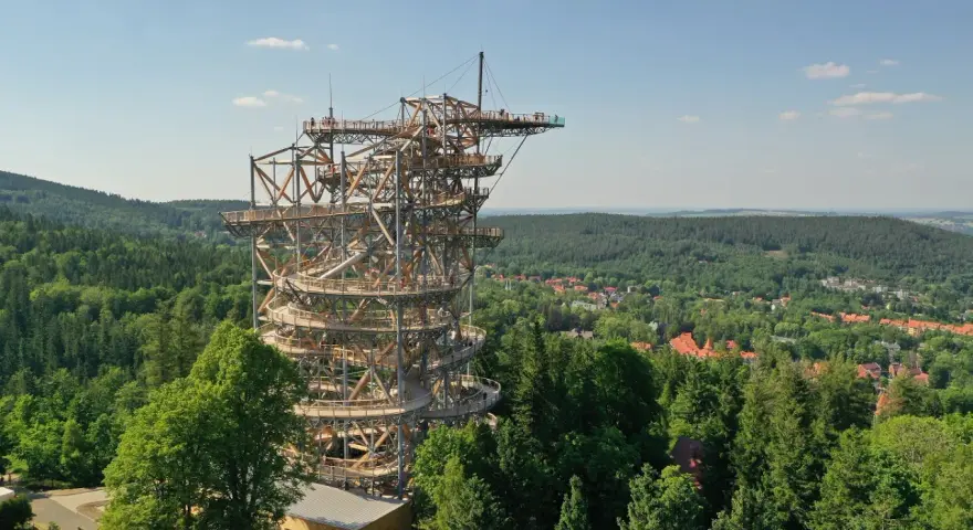 Drewniana wieża Sky Walk wznosi się ponad zielonym lasem, oferując zapierające dech w piersiach widoki na okolicę i miasteczko.