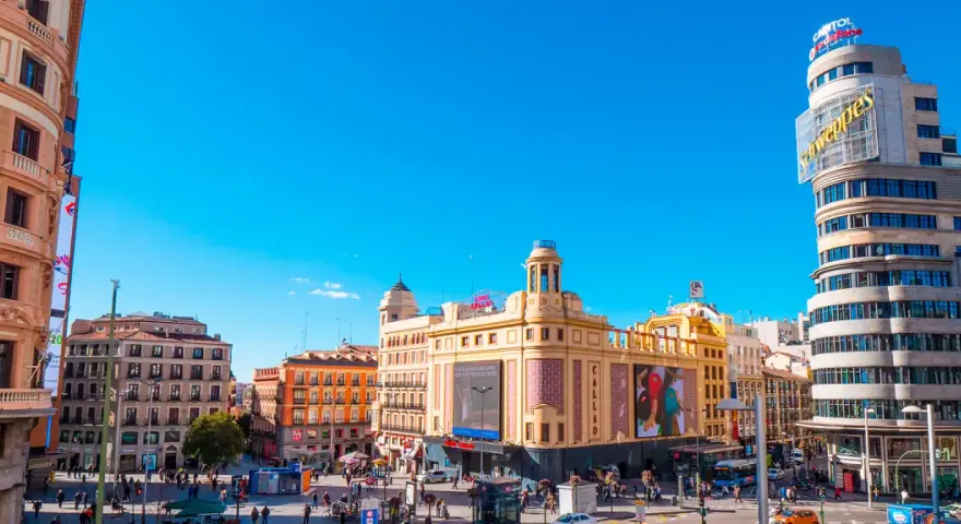Tętniący życiem plac w Madrycie, idealny na jednodniową wycieczkę. Zobaczysz tu charakterystyczny budynek Capitol z neonem Schweppes i kino Callao.