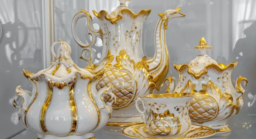 Elegancka zastawa kawowa z Muzeum Porcelany Wałbrzych, zdobiona złotem i motywami roślinnymi, zachwyca kunsztem wykonania.