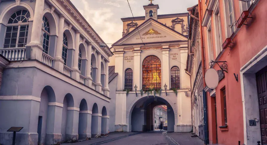 Brama w Ostrej Bramie, serce starego miasta Wilna, wita przechodniów łukiem i zabytkową architekturą.