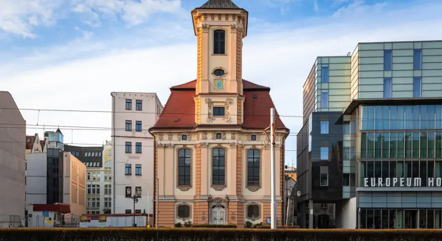 Wrocławski **dzielnica czterech świątyń** to kontrast historii i nowoczesności. Stara kamienica obok szklanego hotelu.