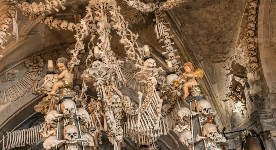 Wnętrze Kaplicy Czaszek w Kutnej Horze. Ludzkie kości i czaszki tworzą żyrandol i dekoracje.