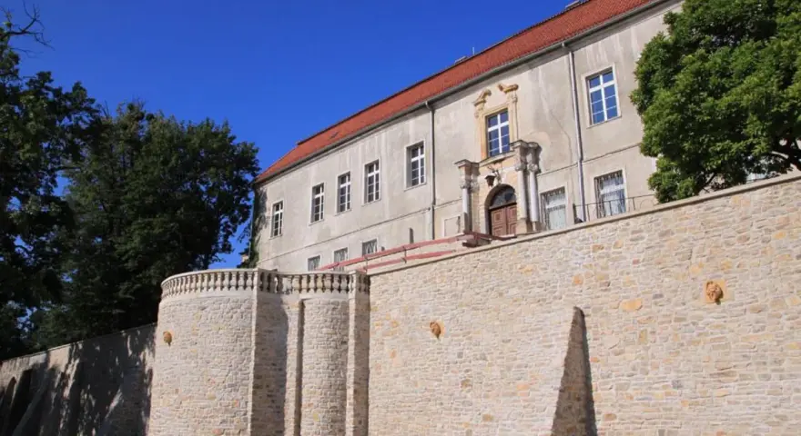 Krapkowice zamek zwiedzanie: kamienne mury i zabytkowy budynek zamku pod błękitnym niebem.