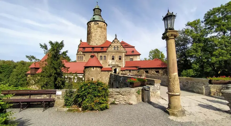 Zamek Czocha, gdzie jest? Ten malowniczy zamek z czerwonymi dachami i wieżą góruje nad okolicą, otoczony zielenią.