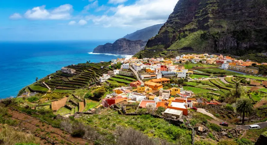 Kolorowa wioska na zboczu góry, tarasowe pola i ocean. To jedne z wielu **la gomera atrakcje**, które zachwycają.