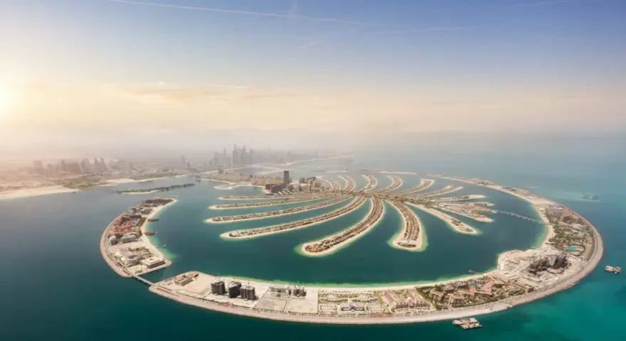 Palma Jumeirah, jedna z najbardziej spektakularnych dubajskich atrakcji, rozpościera się na tle błękitnego nieba i turkusowego morza.
