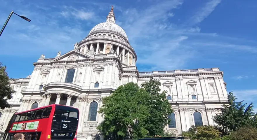 Majestatyczna katedra św. Pawła w Londynie, czerwony piętrowy autobus i błękitne niebo. Idealny widok na udany weekend w Londynie.