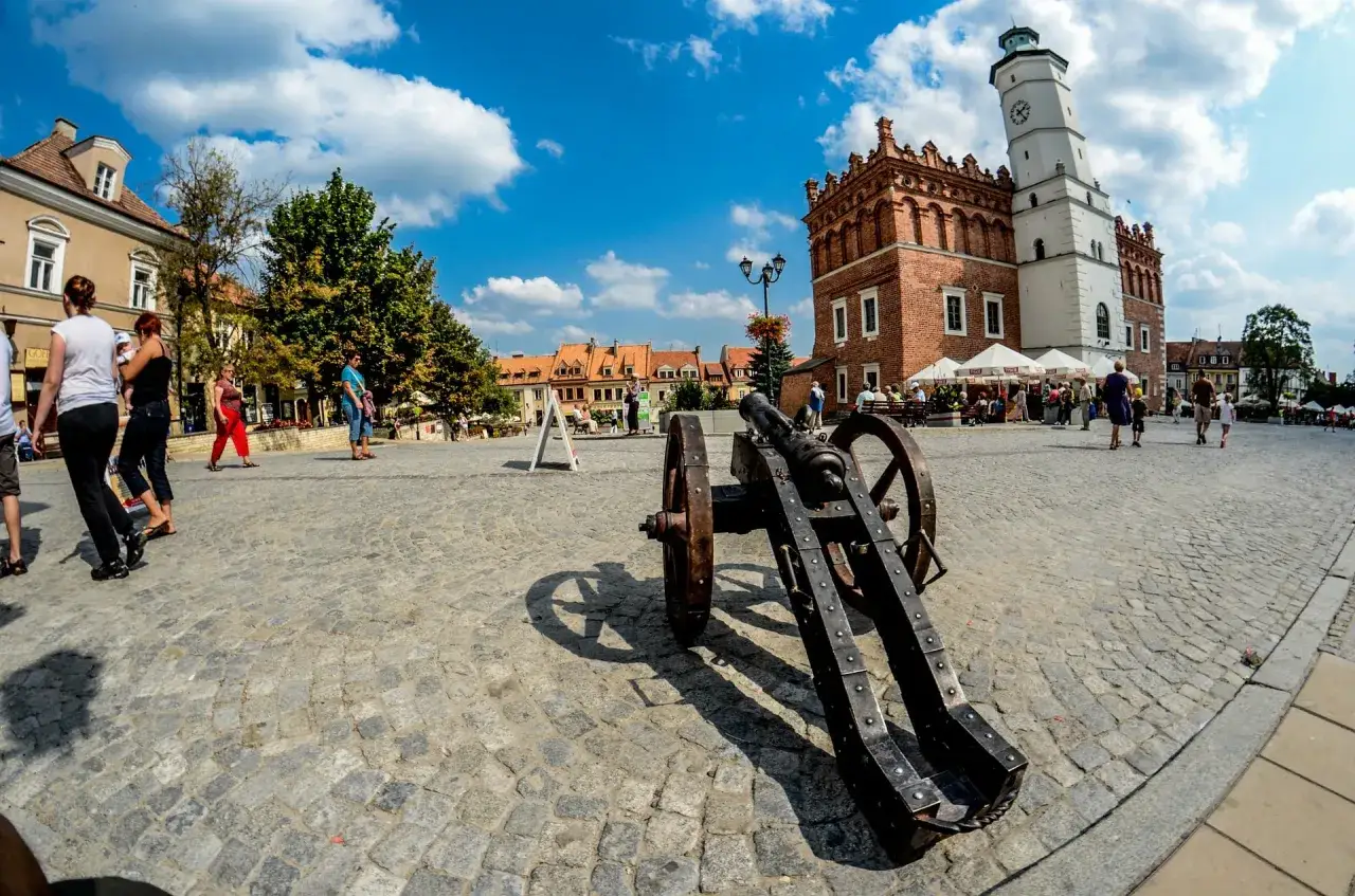 Rynek w Sandomierzu z Ratuszem i armatą. Atrakcje turystyczne miasta zachęcają do spacerów.