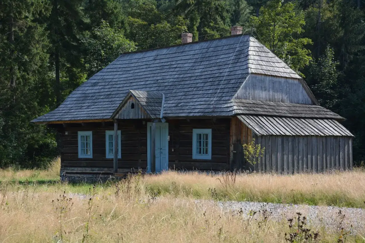 Drewniana chata w Zubrzycy G&oacute;rnej, jedna z atrakcji regionu, otoczona dziką przyrodą.